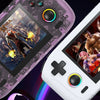 Close-up of two handheld gaming consoles, one purple and one white, displaying video games on their screens.