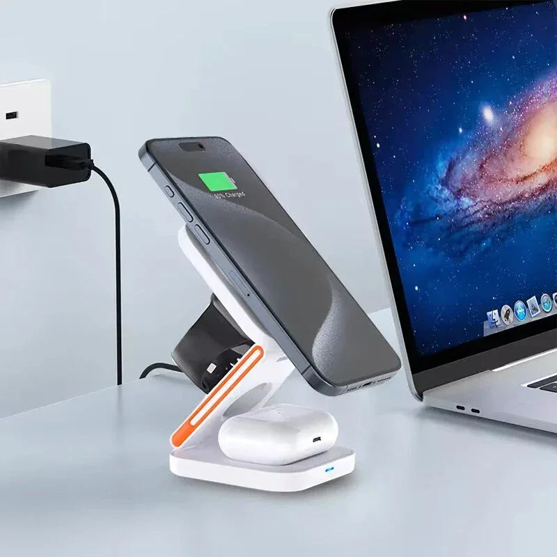 Wireless charging station with smartphone, smart watch, and earbuds next to a laptop