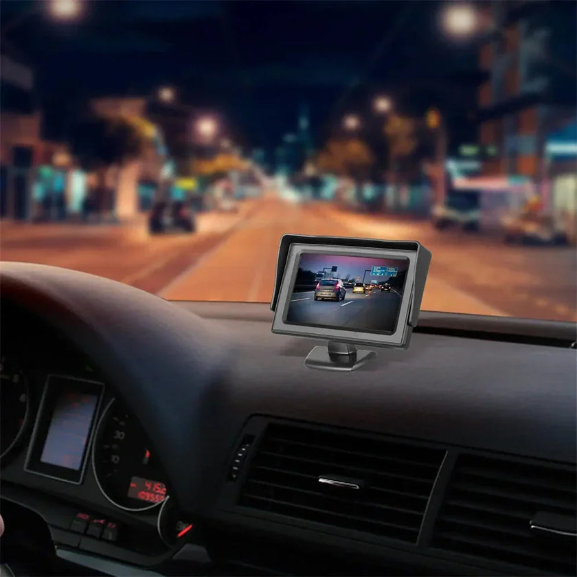 Car dashboard with night driving monitor displaying road and traffic camera view