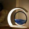 Modern LED night lamp with circular sand art on a bedside table
