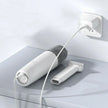 White portable handheld vacuum cleaner charging on tabletop with brush attachment