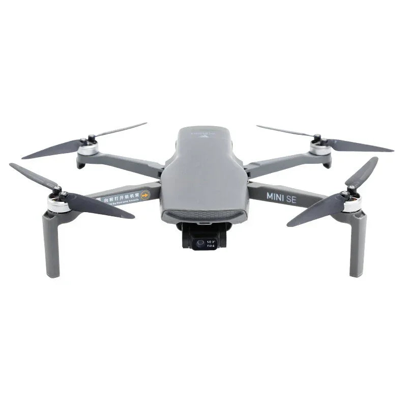 Gray DJI Mini SE drone with camera and four propellers on a white background