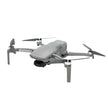 Compact gray camera drone with four propellers and folding arms on white background