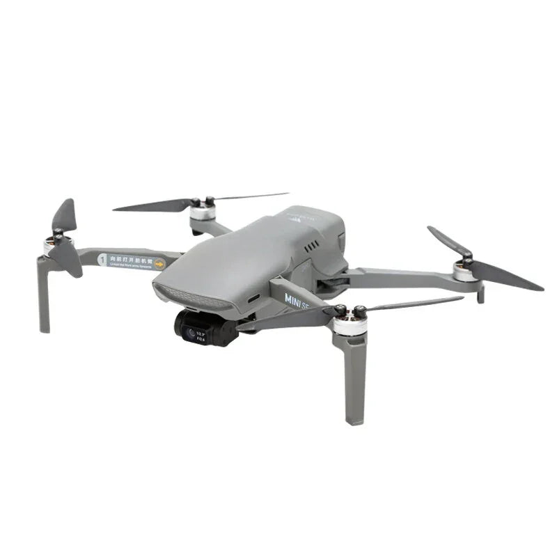 Compact gray camera drone with four propellers and folding arms on white background
