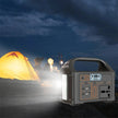 Portable power station lighting up campsite with tent and two people at night outdoors