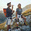 Hikers on a mountain trail with a portable power station and camera gear at sunrise