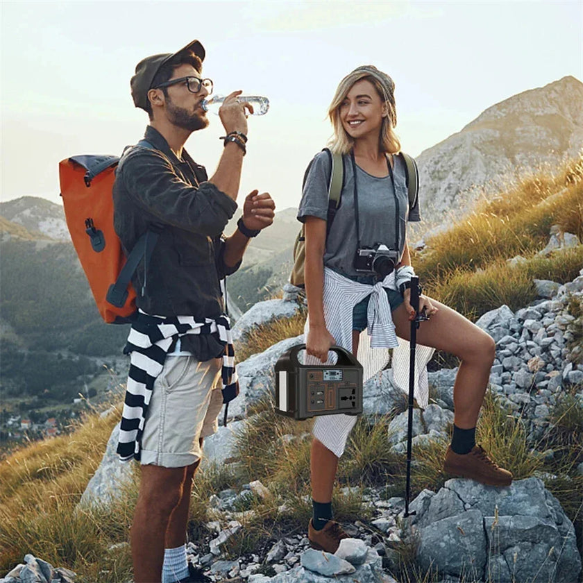 Hikers on a mountain trail with a portable power station and camera gear at sunrise