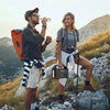 Hikers on a mountain trail with a portable power station and camera gear at sunrise