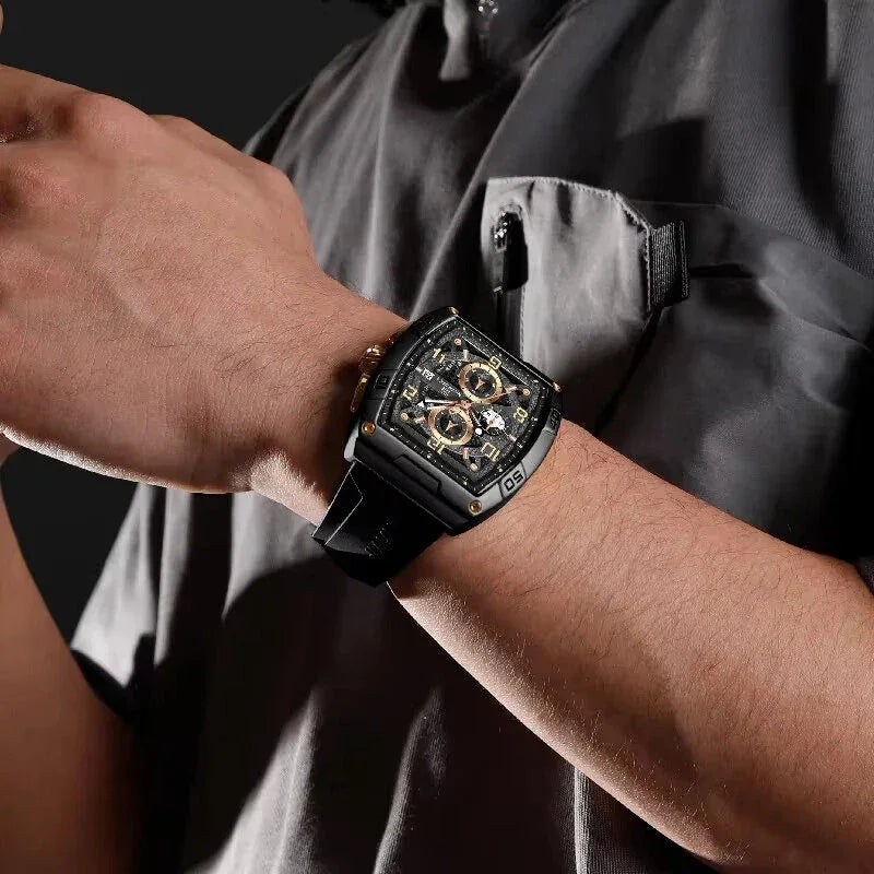 Man wearing black luxury skeleton watch with gold accents on wrist, dark shirt background