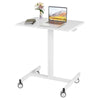 White rolling standing desk with laptop, books, and vase of flowers on top