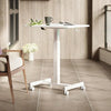 White adjustable rolling desk with mug and book in a modern home office setting