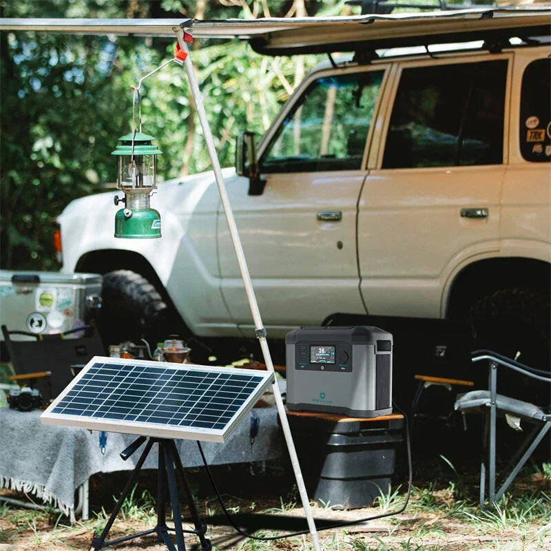 Portable solar panel, power station, and lantern at outdoor camping setup by white SUV