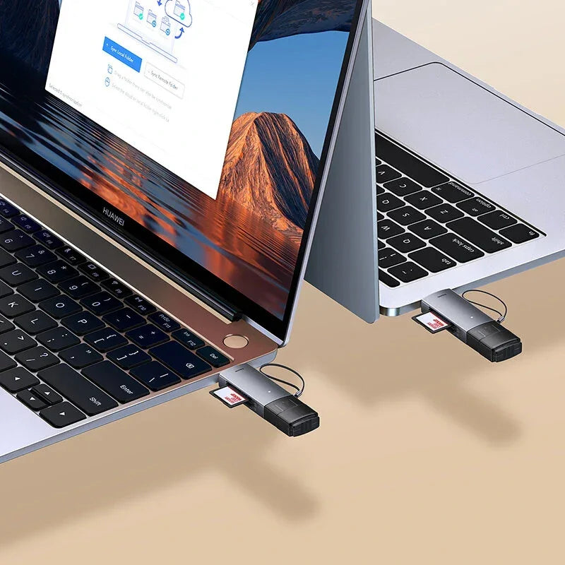 Two laptops with USB-C hubs and SD card readers connected on a beige desk