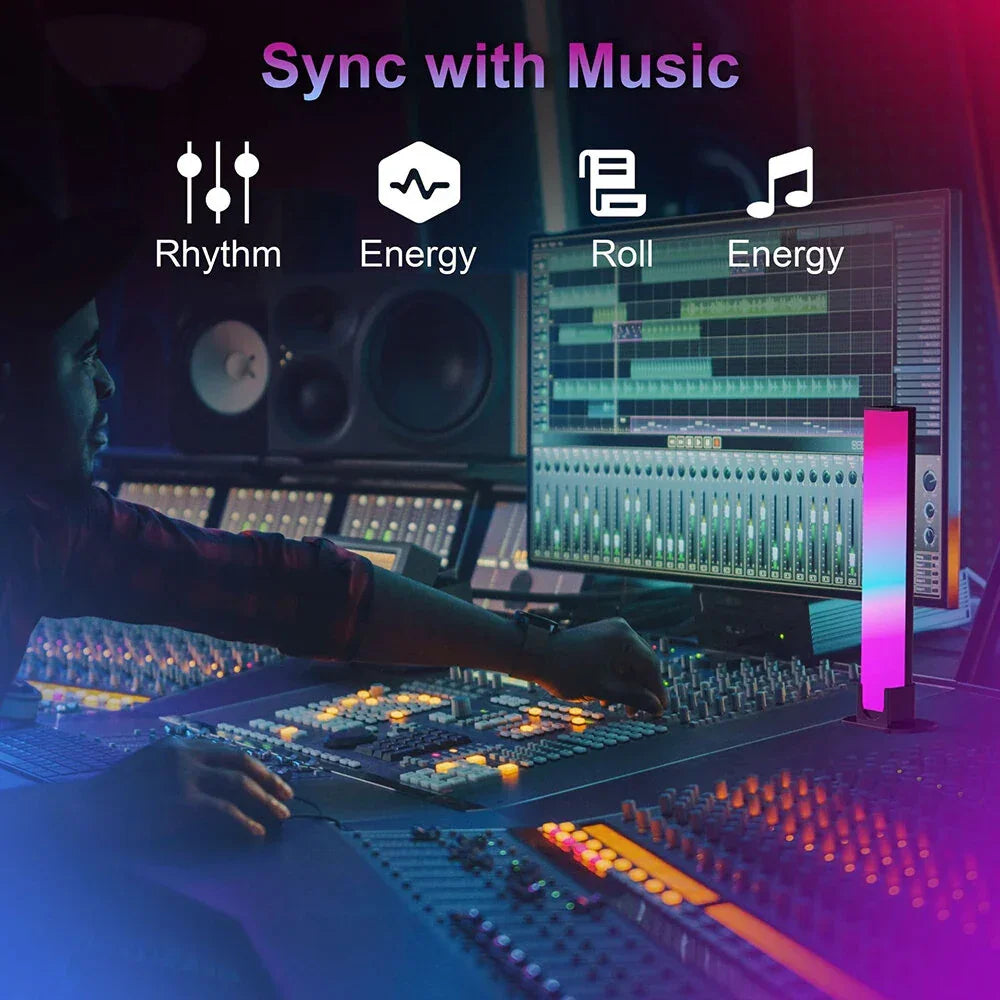 Music producer in recording studio with LED light bar, mixing console, and colorful screens