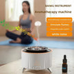 Aromatherapy machine diffuser with humidification, flame simulation, audio, and essential oil, woman meditating in background.