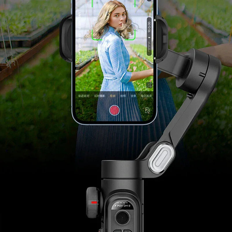 Smartphone gimbal filming woman in blue dress outdoors, mobile video stabilizer demo