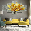 Modern living room with yellow sofa set, geometric cushions, and large yellow flower wall art.