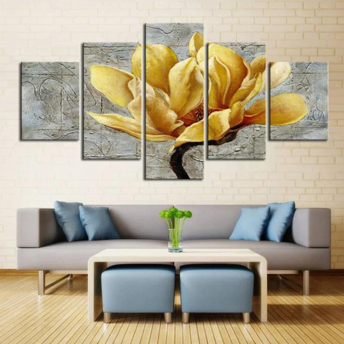 Yellow flower wall art above modern gray sofa in living room with blue pillows and coffee table.