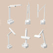 Adjustable white LED desk lamp with storage base shown in six positions on beige background