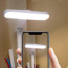 Person taking photo of modern white LED desk lamp above organized pencils and ruler