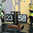 Retro flip clock with black cards and white numbers on a wooden base, modern decor background